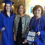 Two graduates posing with Dean Hiskes